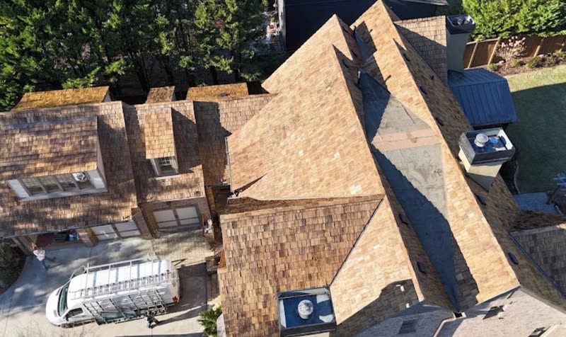 Large home with a full cedar shake roof photographed from above