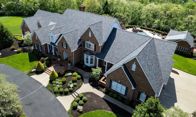 Large brick estate home with a newly installed designer asphalt shingle roof