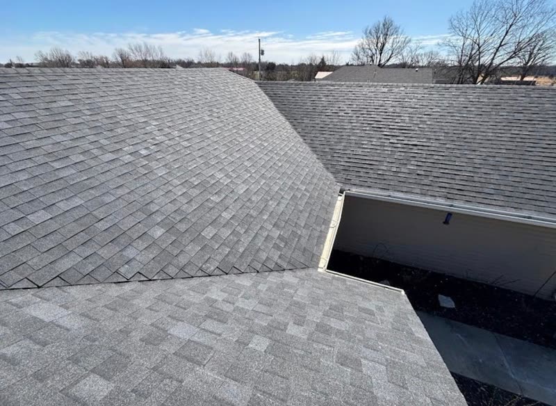 New shingle roof planes meeting at the ridge and valley of a single-storey home
