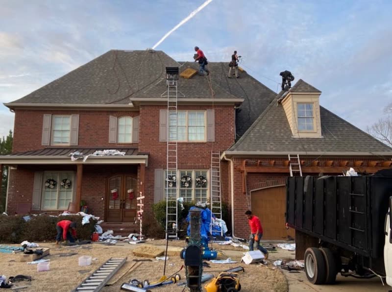 Tear-off debris going straight into a dump trailer parked at the front of the house