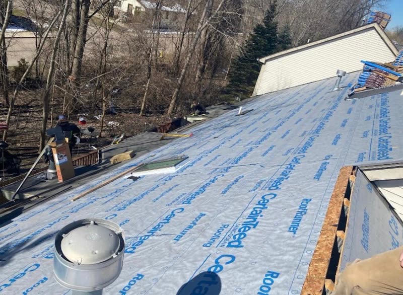 Low-slope section dried in with synthetic underlayment around a roof penetration